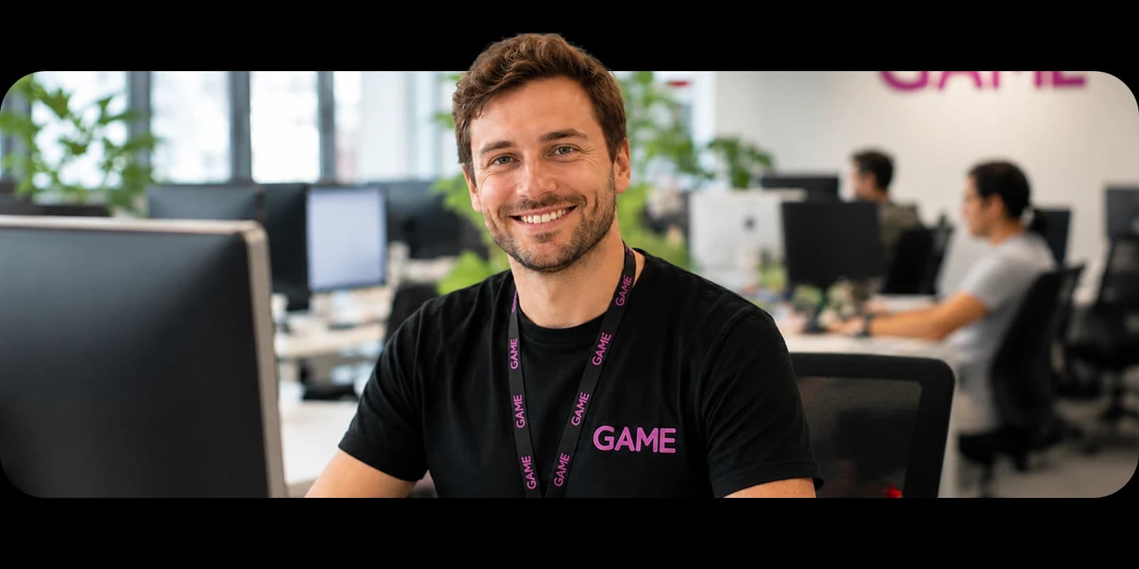 Agente de atención al cliente de GAME con auriculares, sonriendo en su puesto de trabajo